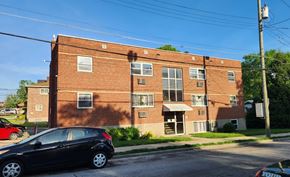Cincinnati apartment for rent - A black car is parked in front of a red brick building.