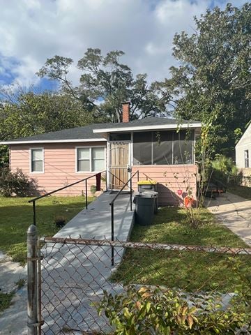 Jacksonville house for rent - a small pink house with a porch and a chain link fence