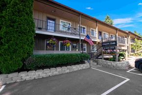 Vancouver apartment for rent - A building with a sign that says "Colony Park" is surrounded by a well-manicured hedge.