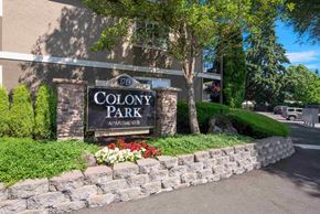 Vancouver apartment for rent - A sign for Colony Park Apartments is surrounded by a stone wall and greenery.