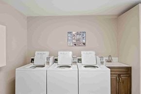 Vancouver apartment for rent - a laundry room with four washer and dryers in it