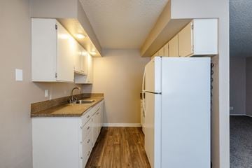 Vancouver apartment for rent - A kitchen with white cabinets and a white refrigerator.