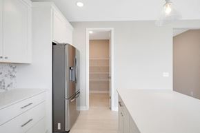 Hudson house for rent - a renovated kitchen with white cabinets and a stainless steel refrigerator