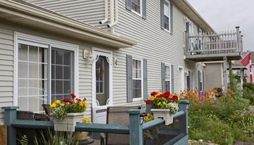 Charlottetown apartment for rent - A house with a grey siding and a white door with a window above it.