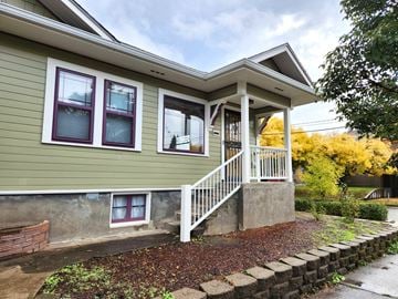 Portland apartment for rent - A house with a green siding and a white porch.
