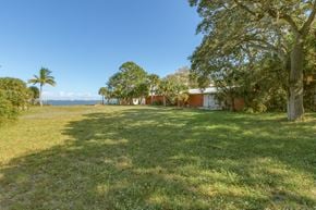 Palm Bay house for rent - a house on the side of a field with grass and trees