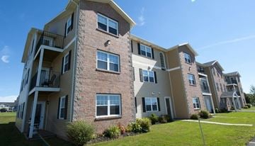 Stratford apartment for rent - A multi-story apartment building with balconies and a clear blue sky.