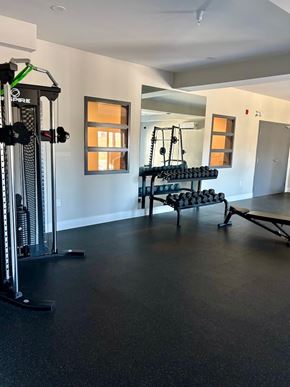 Lantz apartment for rent - A gym with a weight machine, a bench and a rack of dumbbells.