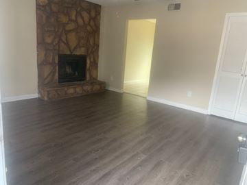 Pensacola house for rent - a living room with wooden floors and a stone fireplace