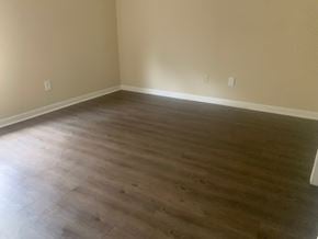 Pensacola house for rent - an empty room with wooden floors and tan walls