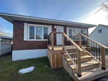 Trenton apartment for rent - A house with a wooden deck and a red brick wall.