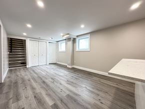 Trenton apartment for rent - A spacious room with wooden flooring and a staircase on the left.