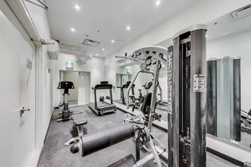 Toronto apartment for rent - A gym with a variety of equipment including a leg press machine.