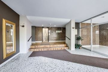 Don Mills apartment for rent - A hallway with a brown carpet and a glass wall.