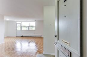 Don Mills apartment for rent - A room with a wooden floor and a door with a sign that says "No Junk Mail".