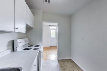 Don Mills apartment for rent - A kitchen with white cabinets and a stove top oven.