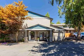 Vancouver apartment for rent - A building with a blue roof and a parking lot in front.