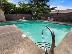 Vancouver apartment for rent - a swimming pool with a fence and chairs and a tree