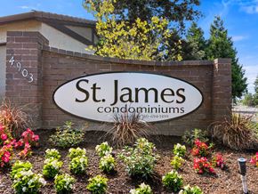 Vancouver apartment for rent - A sign for St. James Condominiums is surrounded by flowers.