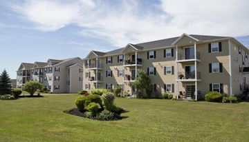 Stratford apartment for rent - A row of townhouses with a green lawn in front.