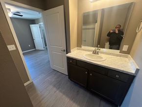 Dodge City apartment for rent - A bathroom with a sink, mirror, and a person taking a photo.