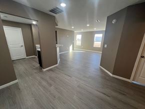 Dodge City apartment for rent - A spacious room with wooden flooring and a white door.