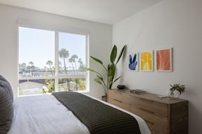 San Diego apartment for rent - a bedroom with a large window and a bed and a dresser