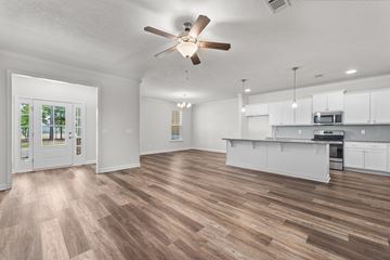 Aiken house for rent - an open kitchen and living room with a ceiling fan