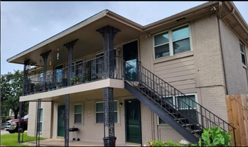 Houston apartment for rent - A two-story house with a balcony and staircase.