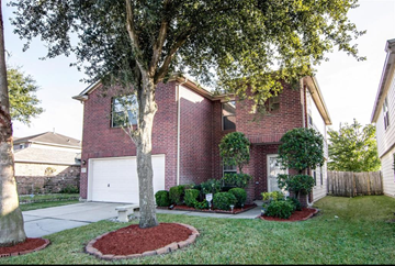 Houston house for rent - A house with a red brick exterior and a white garage door.