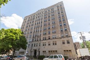 Chicago apartment for rent - a tall building with cars parked in front of it
