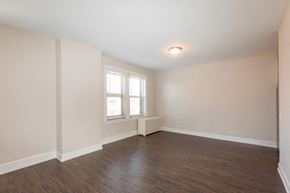 Chicago apartment for rent - the spacious living room with wood flooring and a window