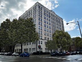 Chicago apartment for rent - a tall building with cars parked in front of it on a city street