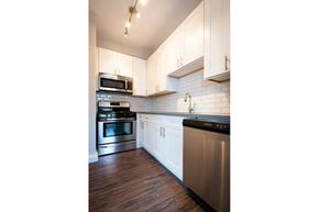 Chicago apartment for rent - a kitchen with white cabinets and stainless steel appliances
