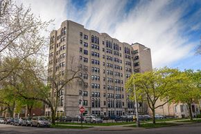 Chicago apartment for rent - a tall building with cars parked in front of it