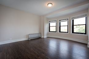 Chicago apartment for rent - an empty living room with wood flooring and three windows