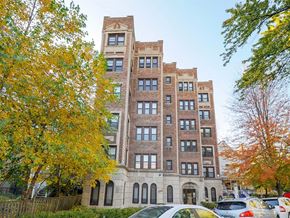 Chicago apartment for rent - a tall brick building with cars parked in front of it