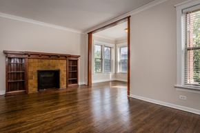 Chicago apartment for rent - an empty living room with a fireplace and wooden floors