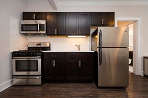 Chicago apartment for rent - a kitchen with stainless steel appliances and black cabinets