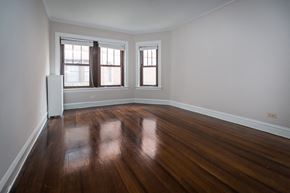 Chicago apartment for rent - an empty living room with wooden floors and windows