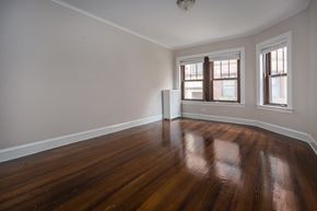 Chicago apartment for rent - an empty living room with wood floors and a window