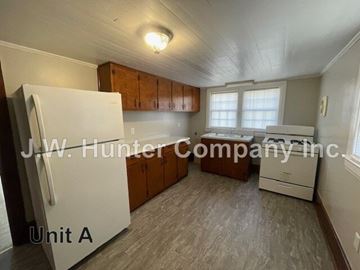 Stantonsburg apartment for rent - A kitchen with a white fridge and wooden cabinets.
