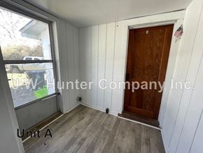 Stantonsburg apartment for rent - A room with a wooden door and a window with a view of a yard and a car.
