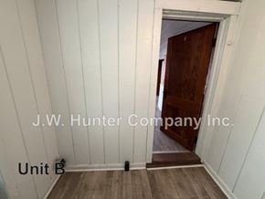 Stantonsburg apartment for rent - A white room with wood flooring and a doorway leading to another room.