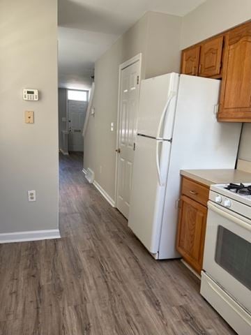 Philaladephia house for rent - A kitchen with a white refrigerator and wooden cabinets.