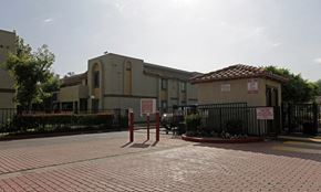 Fontana apartment for rent - A building with a red tile roof and a sign on it.