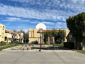 Fontana apartment for rent - A basketball court with a basketball hoop and a building in the background.