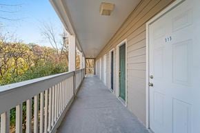 Nashville house for rent - a long porch with a white door and a balcony