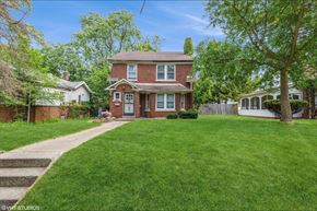 Gary house for rent - a red brick house with a lawn and a sidewalk
