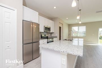 Palm Bay house for rent - a kitchen with a marble counter top and stainless steel refrigerator